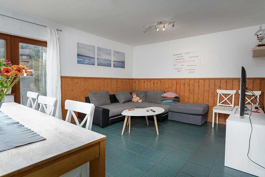 Gemeinschaftsraum mit Sitzecke und Blick zur Terrasse – Raum für Austausch und Begegnung